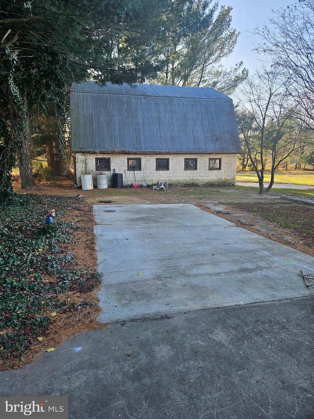 view of side of property featuring metal roof and a gambrel roof