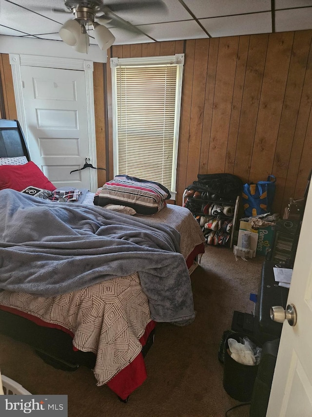 carpeted bedroom featuring wooden walls