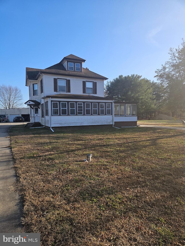 american foursquare style home with a sunroom and a front yard