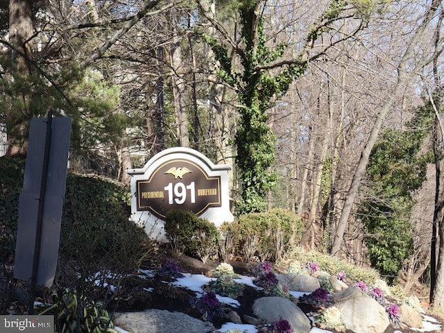 community sign featuring a wooded view