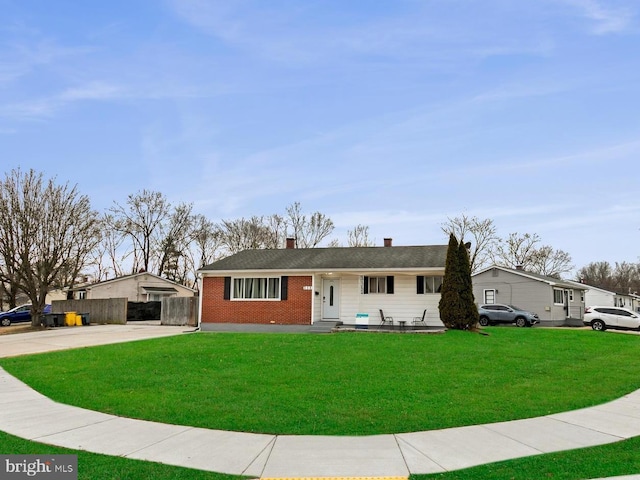 single story home with brick siding, a chimney, a front yard, fence, and driveway