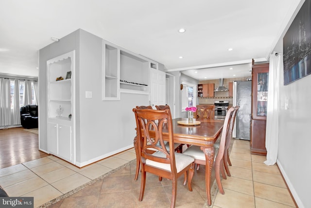 dining area with light tile patterned floors, baseboards, and a healthy amount of sunlight