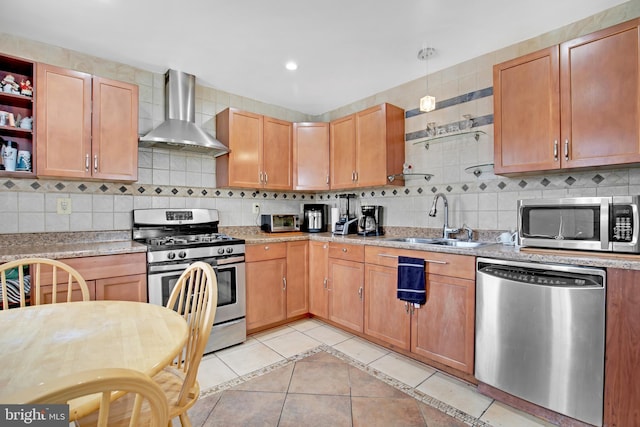 kitchen featuring light countertops, stainless steel appliances, wall chimney range hood, a sink, and light tile patterned flooring