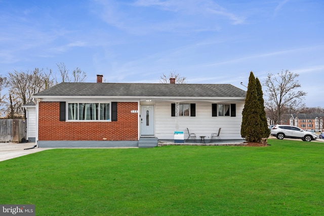 single story home featuring brick siding, a front yard, fence, and a shingled roof