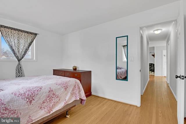 bedroom with baseboards and light wood finished floors