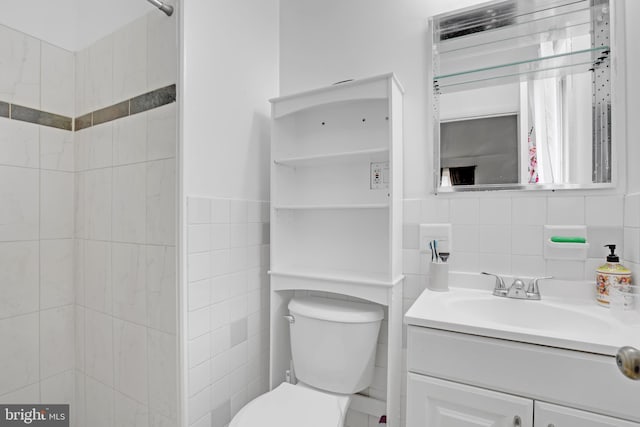 full bath with tile walls, toilet, and vanity