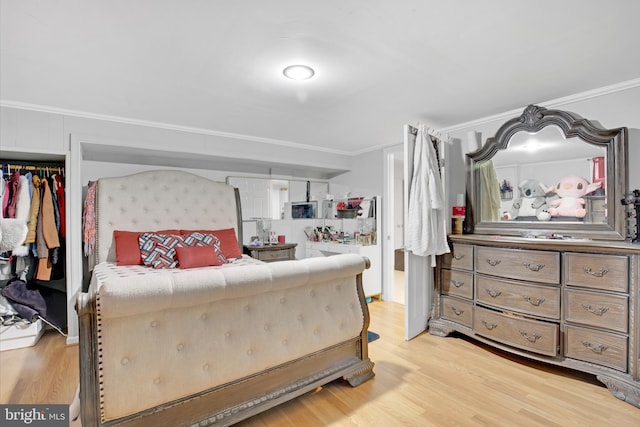 bedroom with light wood-style flooring and ornamental molding