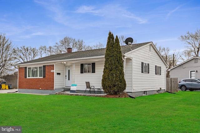 ranch-style house featuring a chimney, fence, a front lawn, and brick siding