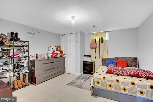 bedroom with tile patterned flooring, a closet, and visible vents