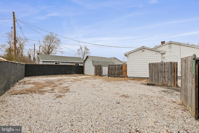 view of yard featuring an outbuilding, a storage unit, and a fenced backyard