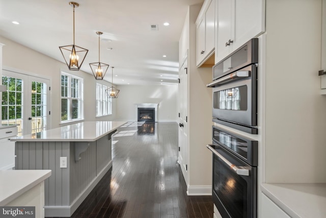 kitchen with white cabinets, dark wood finished floors, light countertops, and recessed lighting