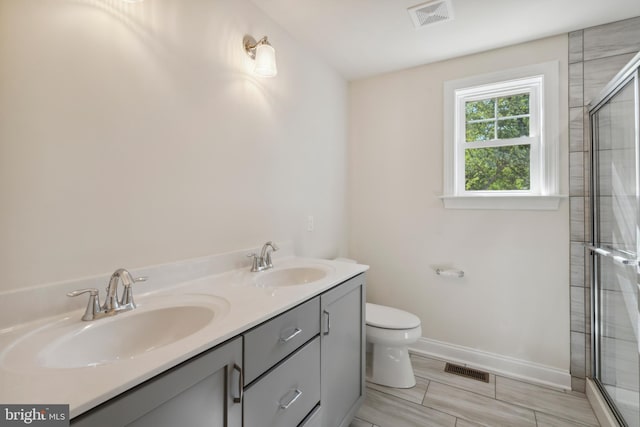 full bathroom with visible vents, a sink, and a tile shower