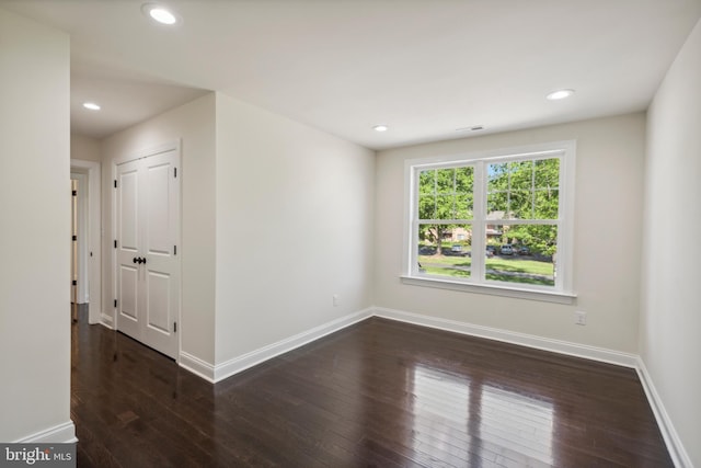 spare room featuring baseboards, dark wood finished floors, and recessed lighting