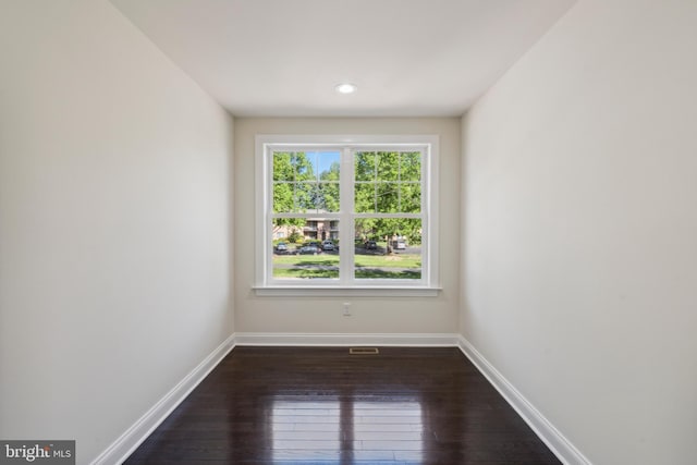 empty room featuring dark wood-style floors and baseboards