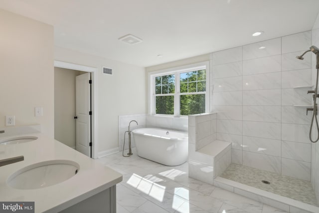 full bathroom featuring a freestanding tub, marble finish floor, visible vents, and a sink