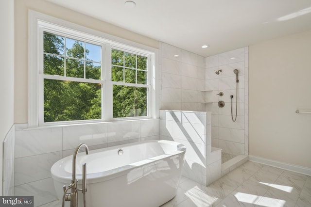 bathroom with marble finish floor, a tile shower, and a wealth of natural light