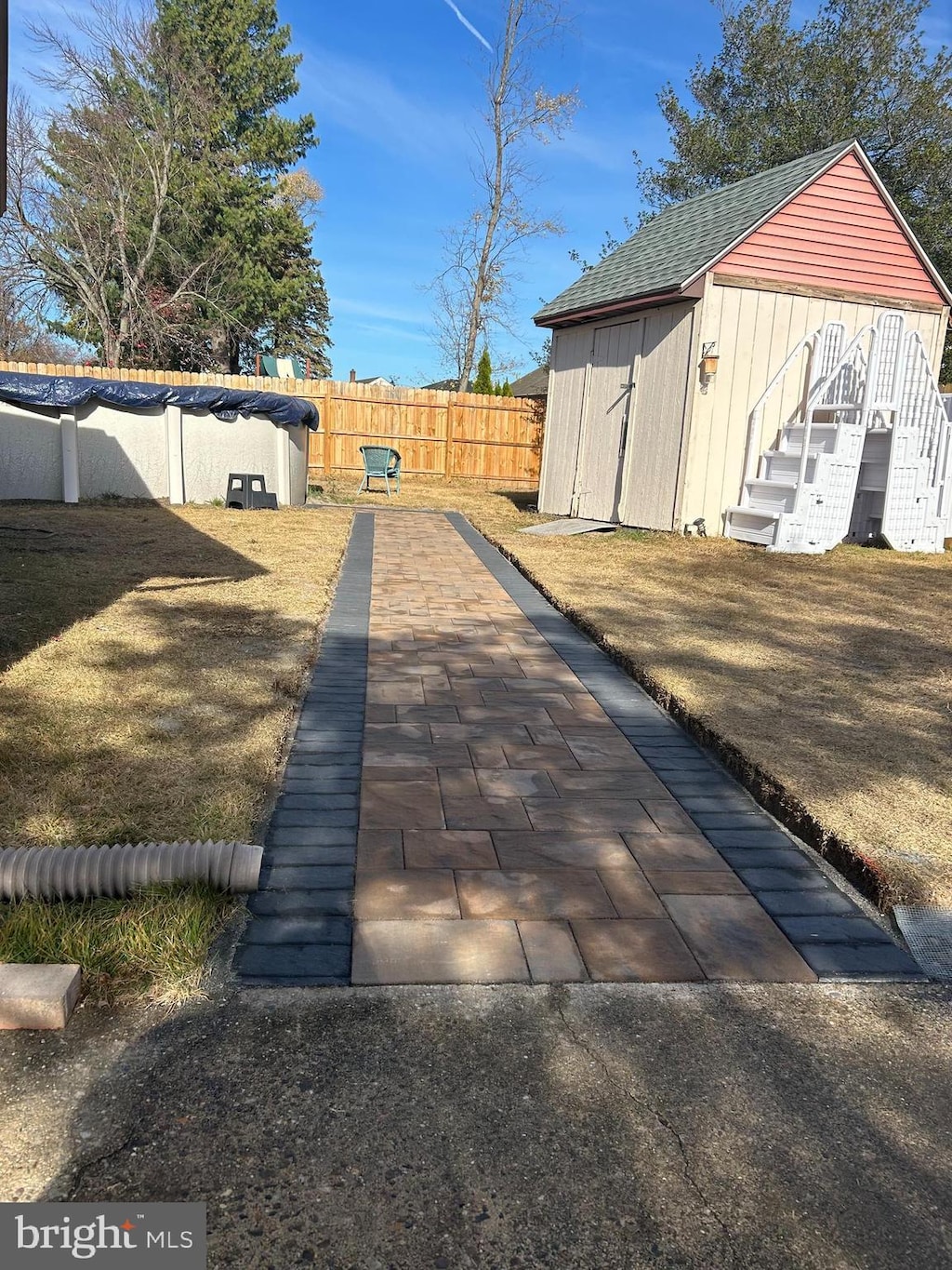 exterior space with a swimming pool, roof with shingles, and a fenced backyard