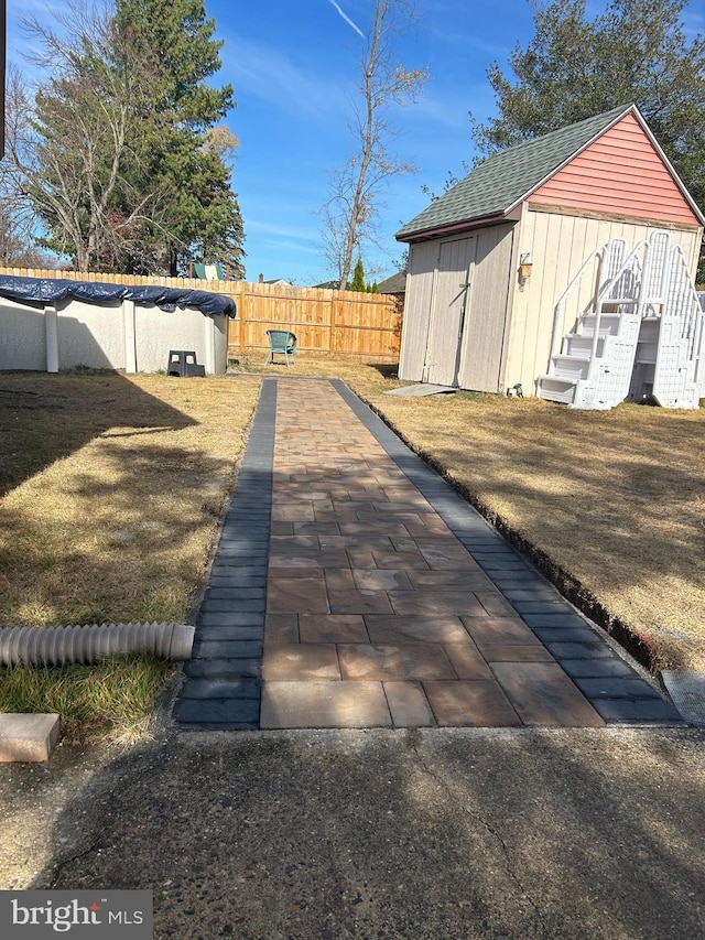 exterior space with roof with shingles and a fenced backyard