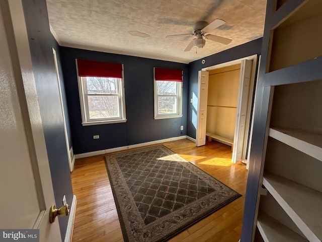 bedroom with baseboards, ceiling fan, and light wood finished floors