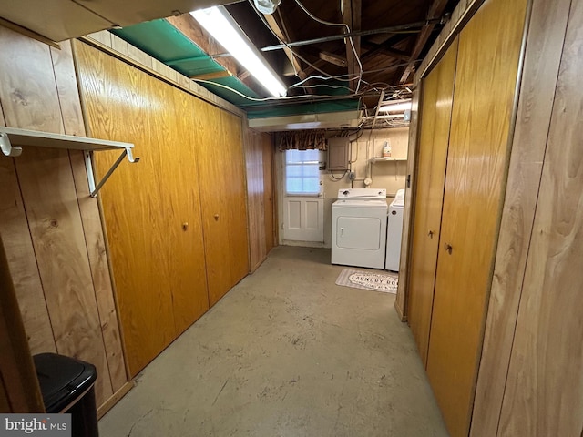 basement featuring wooden walls and washing machine and clothes dryer