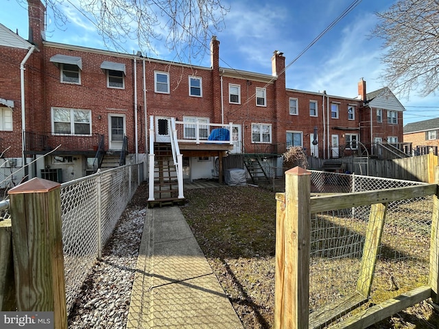 rear view of property with stairs and fence