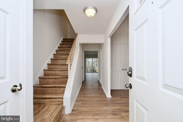 entrance foyer with stairway, light wood-type flooring, and baseboards