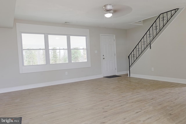 foyer entrance with light wood-type flooring, stairway, and baseboards