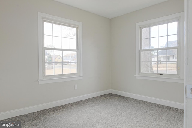 carpeted empty room with plenty of natural light and baseboards