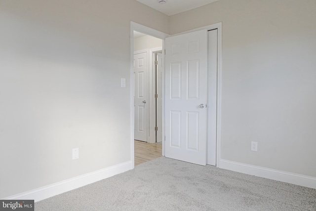 unfurnished bedroom featuring carpet floors and baseboards