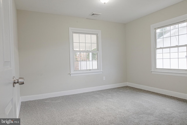 carpeted empty room with baseboards, visible vents, and a healthy amount of sunlight