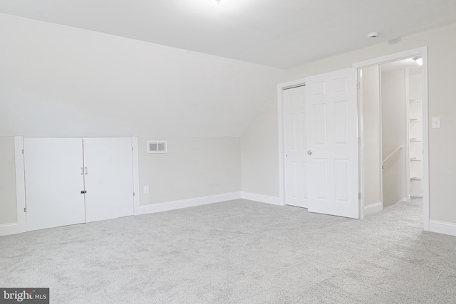 additional living space featuring vaulted ceiling, carpet, visible vents, and baseboards