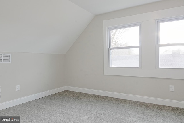 bonus room featuring lofted ceiling, carpet, visible vents, and baseboards