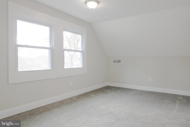 additional living space with lofted ceiling, carpet flooring, visible vents, and baseboards