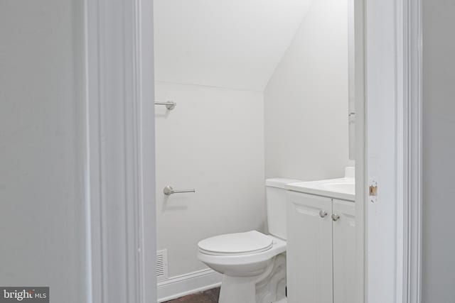 bathroom featuring toilet, visible vents, lofted ceiling, and vanity