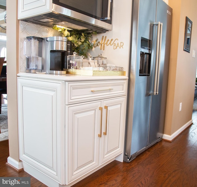 bar with baseboards, appliances with stainless steel finishes, and dark wood-style flooring