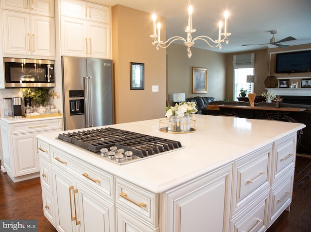 kitchen with open floor plan, stainless steel appliances, dark wood-type flooring, and light countertops