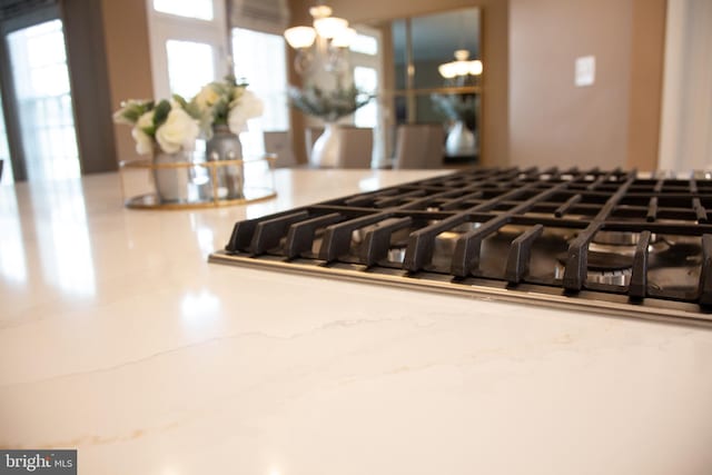 interior details with stainless steel gas cooktop and a notable chandelier