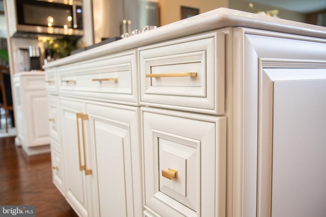 room details with stainless steel microwave and wood finished floors