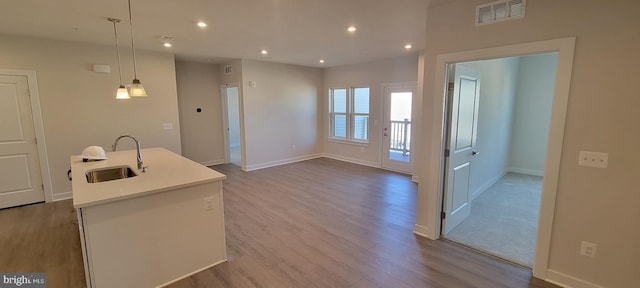 kitchen with recessed lighting, visible vents, a sink, wood finished floors, and baseboards