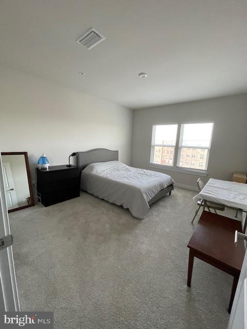 bedroom with carpet, visible vents, and baseboards