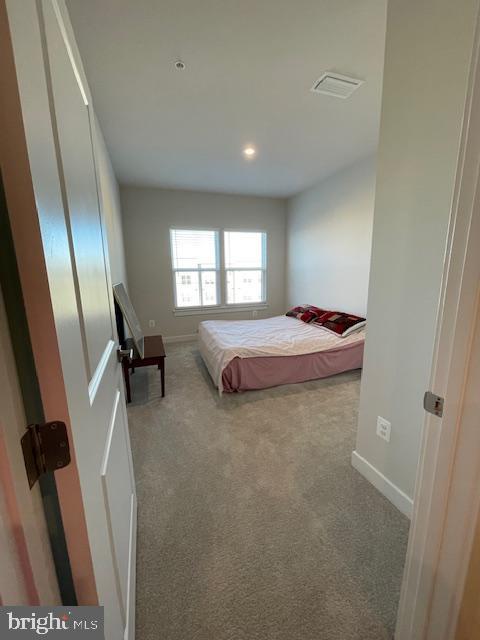 carpeted bedroom with visible vents and baseboards