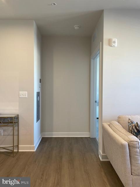 hallway with dark wood-type flooring and baseboards