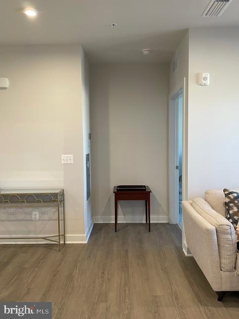 hallway with baseboards, visible vents, wood finished floors, and recessed lighting