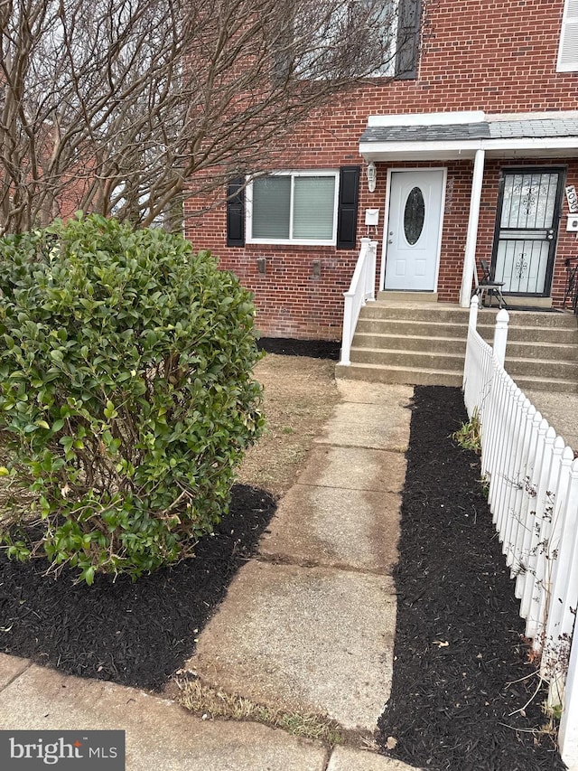 property entrance featuring brick siding