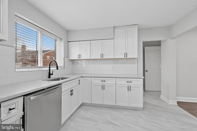 kitchen with tasteful backsplash, white cabinets, light stone countertops, stainless steel dishwasher, and a sink