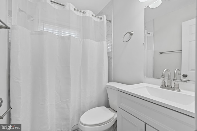 full bath with curtained shower, vanity, and toilet