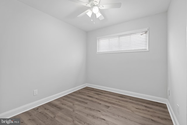 empty room featuring ceiling fan, baseboards, and wood finished floors