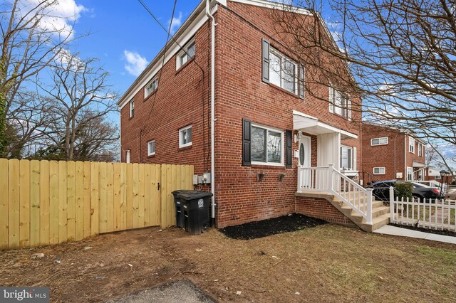 view of home's exterior featuring fence and brick siding