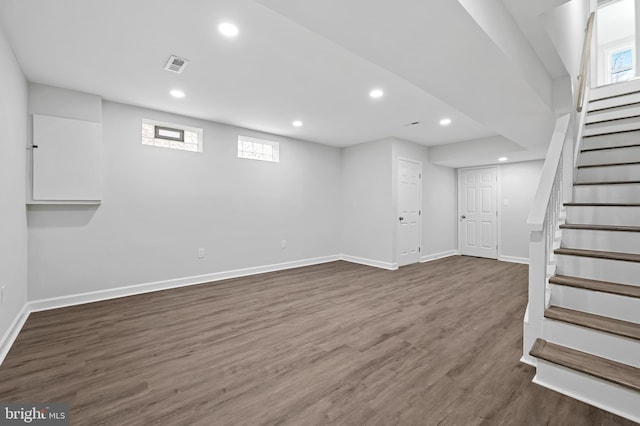 basement featuring stairs, dark wood-style flooring, visible vents, and recessed lighting