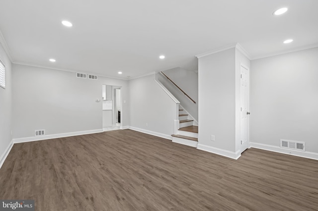 unfurnished living room with dark wood-style flooring, visible vents, crown molding, and stairway